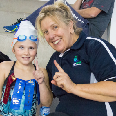 Swim school student Tarlia Rudge shows off her first place ribbons with Aquamoves swimming instructor Megan Birks.